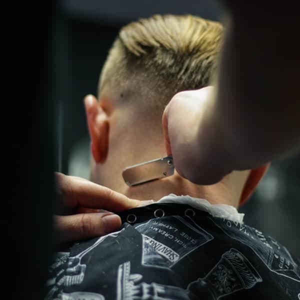 A razor cleaning up the neckline on a fresh fade